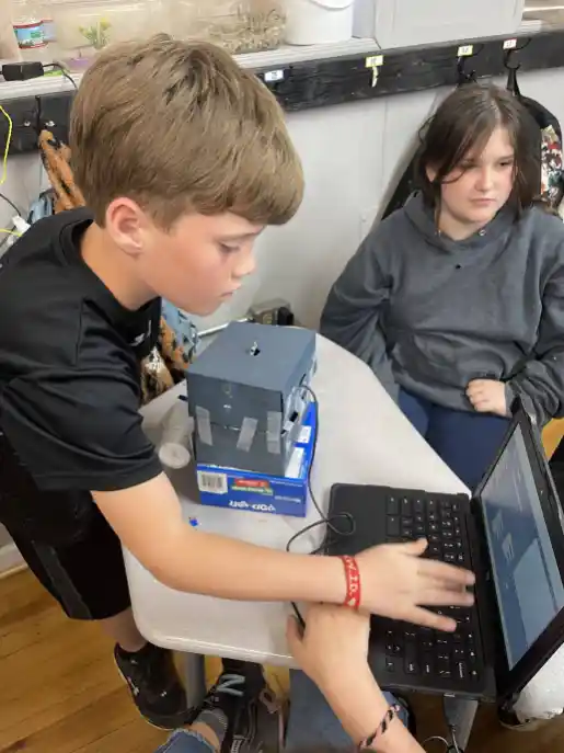 Students work to program robot with sensors through coding. (Merry Martin)
