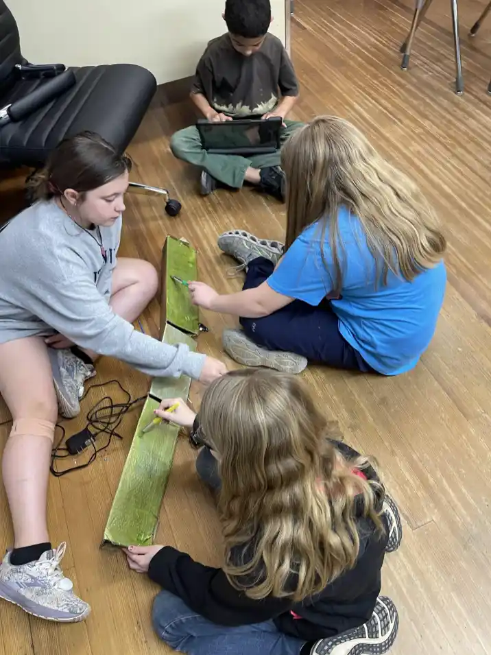 Students work together to paint parts of their robots in STEAM class. (Merry Martin)